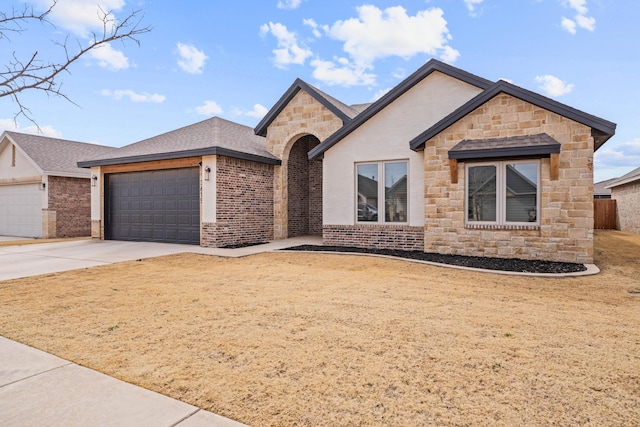3615 121st St, Lubbock, TX 79423 - view of front of property featuring an attached garage, concrete driveway, stone siding, and brick siding