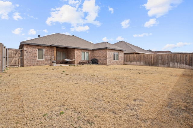 3615 121st St, Lubbock, TX 79423 - back of house featuring brick siding, a fenced backyard, and roof with shingles