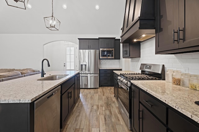 3615 121st St, Lubbock, TX 79423 - kitchen with stainless steel appliances, arched walkways, light stone countertops, pendant lighting, and backsplash