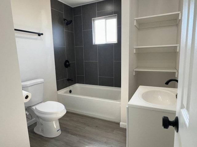 full bathroom featuring vanity, hardwood / wood-style flooring, tiled shower / bath combo, and toilet