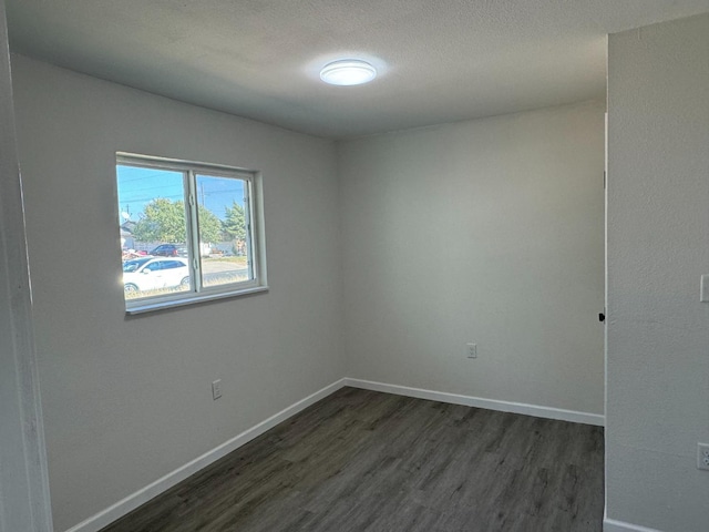 spare room with dark hardwood / wood-style flooring and a textured ceiling