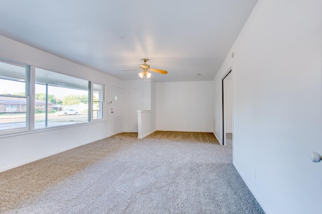 unfurnished room with light colored carpet and ceiling fan