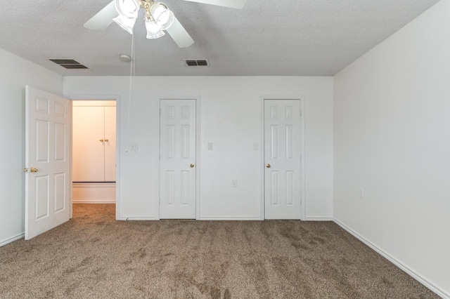 unfurnished bedroom with ceiling fan, carpet floors, and a textured ceiling