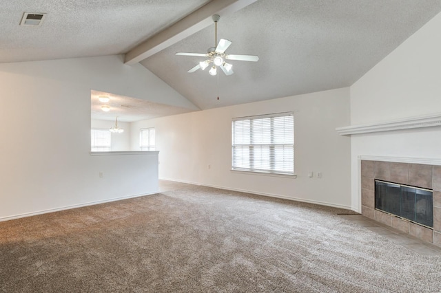 unfurnished living room featuring a wealth of natural light, a tiled fireplace, carpet, and vaulted ceiling with beams