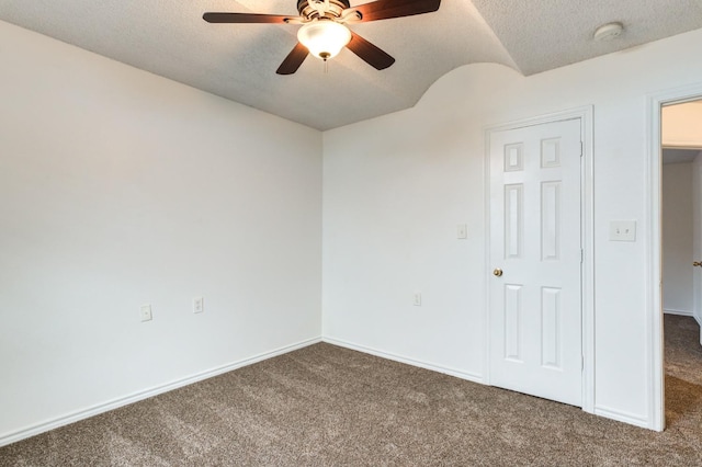 carpeted empty room with ceiling fan and a textured ceiling