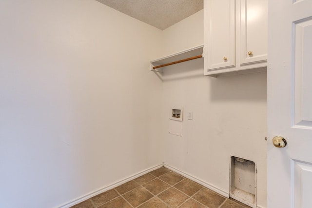 laundry room with cabinets, washer hookup, dark tile patterned flooring, and a textured ceiling