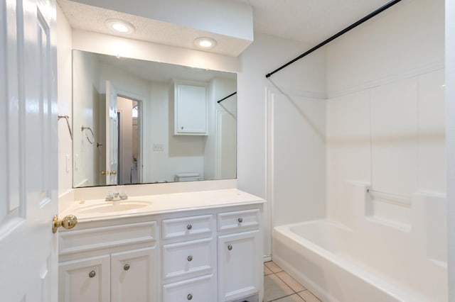 full bathroom with tile patterned floors, toilet,  shower combination, a textured ceiling, and vanity