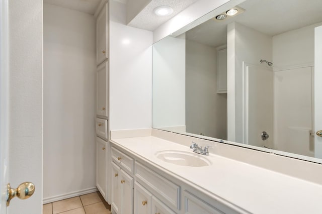 bathroom with washtub / shower combination, vanity, and tile patterned flooring