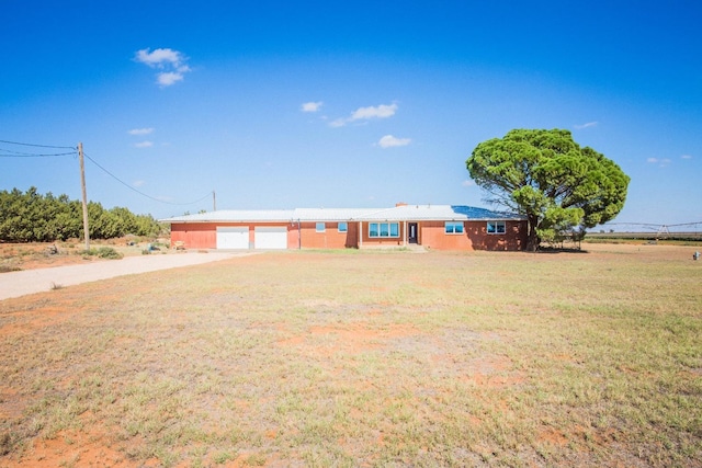 ranch-style house featuring a garage and a front lawn