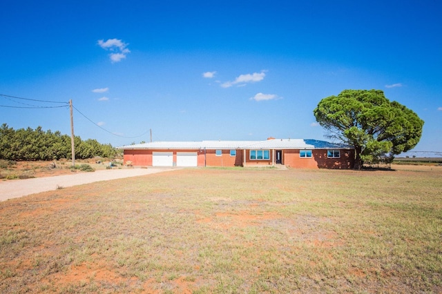 ranch-style home with a garage and a front lawn