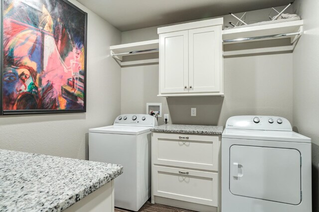 clothes washing area with cabinets and washer and clothes dryer