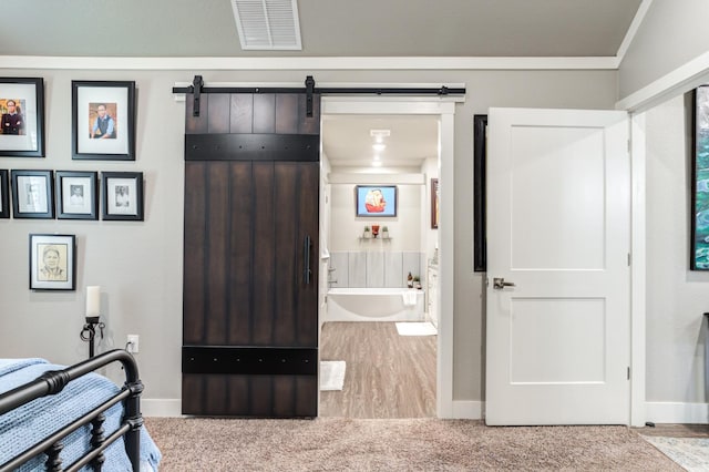 interior space featuring a barn door and connected bathroom