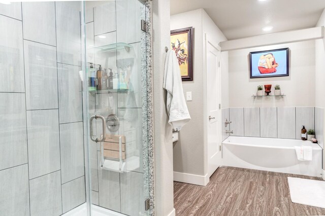 bathroom with wood-type flooring and separate shower and tub