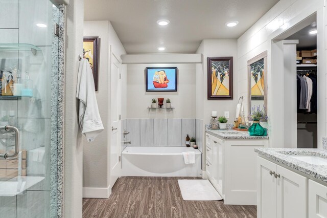 bathroom featuring vanity, hardwood / wood-style flooring, and plus walk in shower