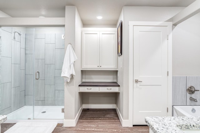 bathroom featuring vanity, an enclosed shower, and wood-type flooring