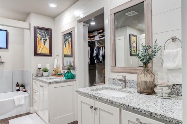 bathroom featuring vanity and a tub to relax in