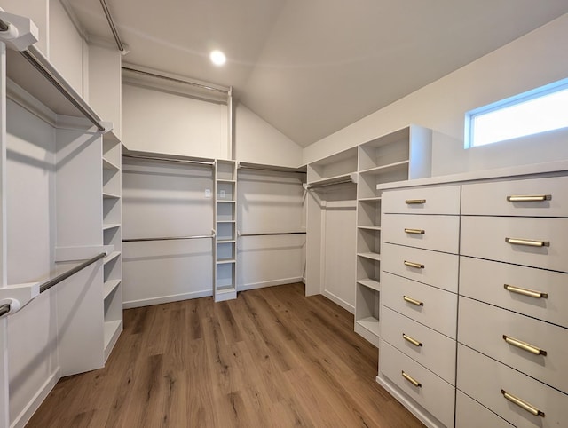 walk in closet featuring light hardwood / wood-style floors and vaulted ceiling