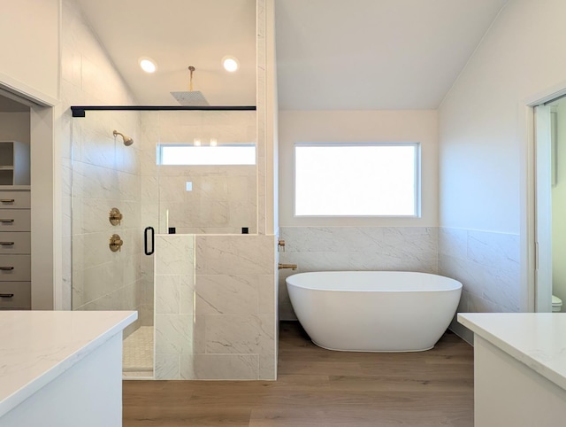 bathroom with vanity, vaulted ceiling, and independent shower and bath