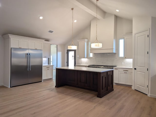 kitchen with white cabinetry, pendant lighting, stainless steel built in fridge, and a kitchen island