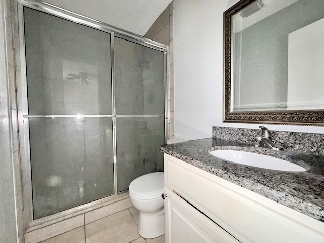 bathroom with vanity, tile patterned flooring, toilet, and walk in shower