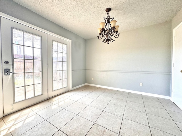 unfurnished dining area featuring a notable chandelier, tile patterned floors, and a textured ceiling