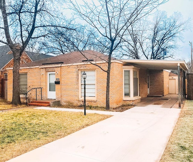 2003 30th St, Lubbock, TX 79411 - single story home with concrete driveway, brick siding, a front yard, and a carport