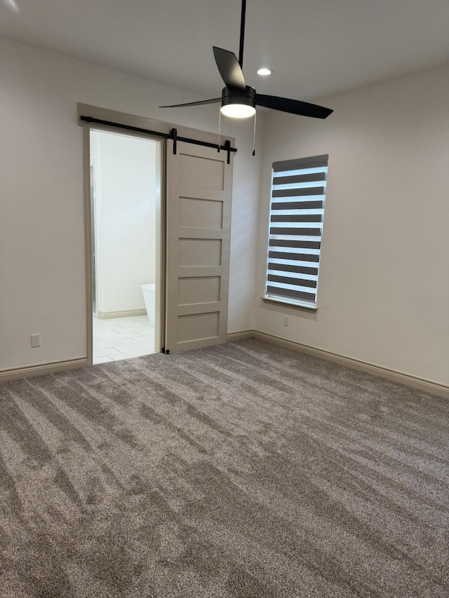 5414 112th St, Lubbock, TX 79424 - empty room featuring ceiling fan, a barn door, carpet, and baseboards