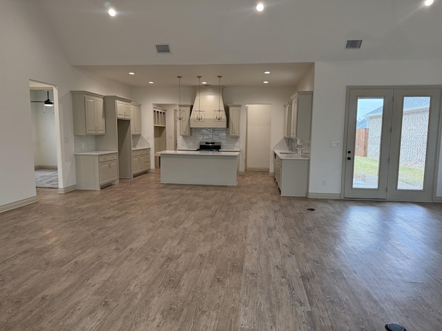 5414 112th St, Lubbock, TX 79424 - kitchen featuring gray cabinets, wood finished floors, custom range hood, decorative backsplash, and recessed lighting