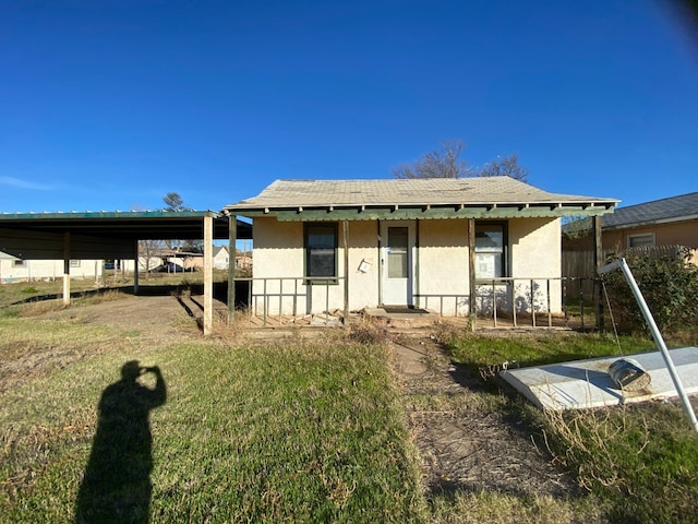 view of front of house with a front yard and a carport