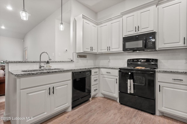 5522 Lehigh St, Lubbock, TX 79416 - kitchen featuring black appliances, white cabinets, a peninsula, light wood-type flooring, and light stone countertops