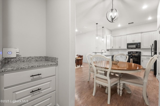 5522 Lehigh St, Lubbock, TX 79416 - dining space with light wood finished floors, recessed lighting, and a chandelier