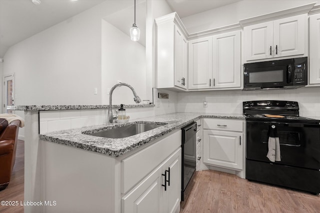 5522 Lehigh St, Lubbock, TX 79416 - kitchen featuring black appliances, light wood-type flooring, white cabinetry, a peninsula, and light stone countertops