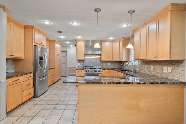 kitchen with sink, decorative light fixtures, kitchen peninsula, stainless steel appliances, and wall chimney range hood