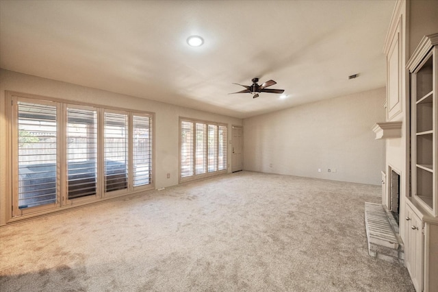 unfurnished living room with ceiling fan and carpet flooring