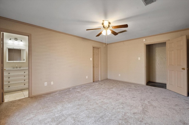 unfurnished bedroom with ensuite bathroom, sink, light carpet, ornamental molding, and ceiling fan