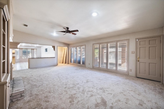 unfurnished living room featuring light carpet, lofted ceiling, and ceiling fan