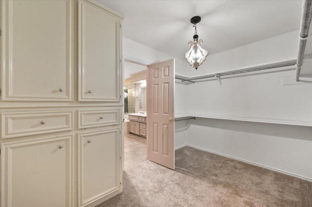 walk in closet featuring light carpet