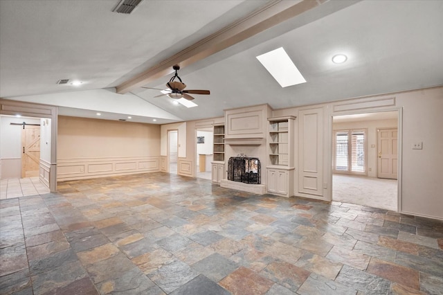 unfurnished living room with lofted ceiling with beams, a barn door, and ceiling fan