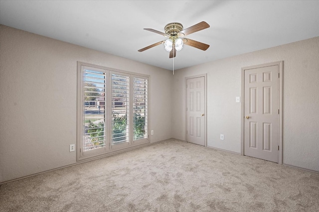 carpeted spare room featuring ceiling fan