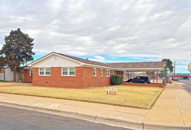 view of front of house with a carport and a front lawn