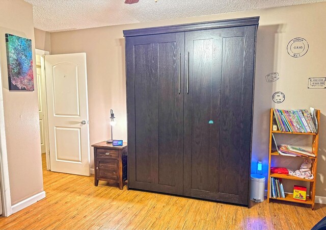 bedroom featuring a textured ceiling and light hardwood / wood-style floors