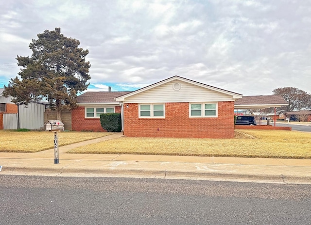 ranch-style house with a carport and a front yard