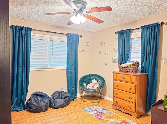 bedroom with ceiling fan, a textured ceiling, and light wood-type flooring