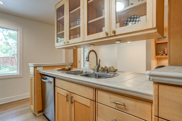 kitchen featuring tile countertops, light brown cabinetry, dishwasher, sink, and light wood-type flooring