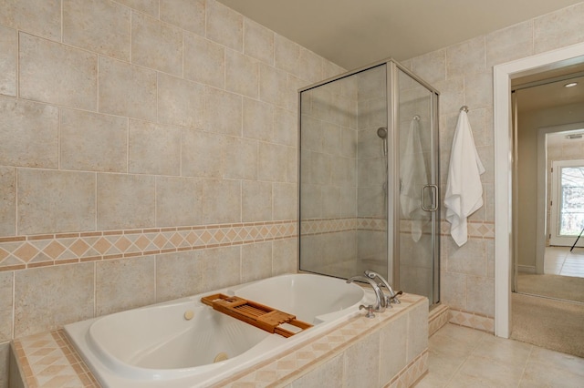 bathroom with tile walls, tile patterned flooring, and separate shower and tub