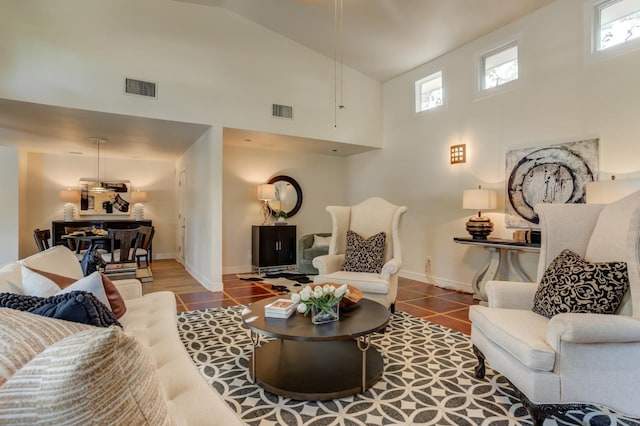 living room with tile patterned flooring and high vaulted ceiling