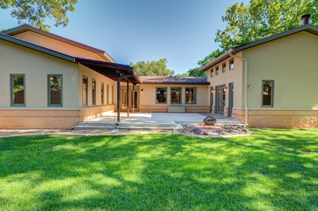 rear view of property featuring a patio area and a lawn