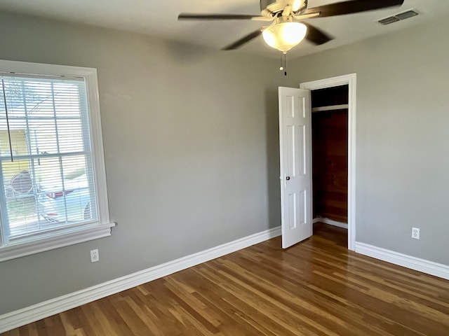 unfurnished bedroom featuring visible vents, ceiling fan, baseboards, and wood finished floors