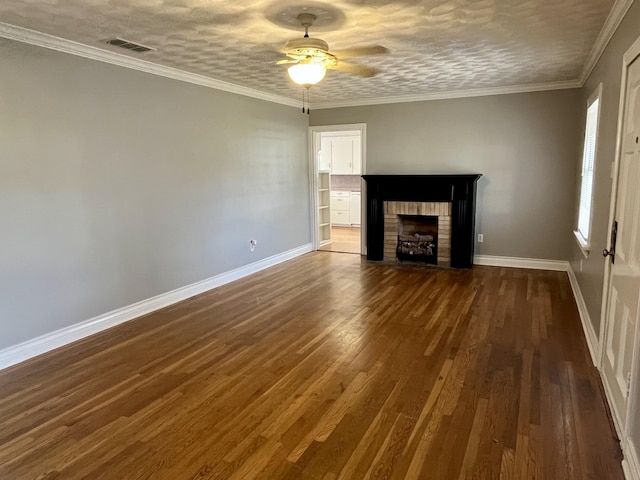 unfurnished living room with dark wood-style floors, a brick fireplace, visible vents, and ornamental molding