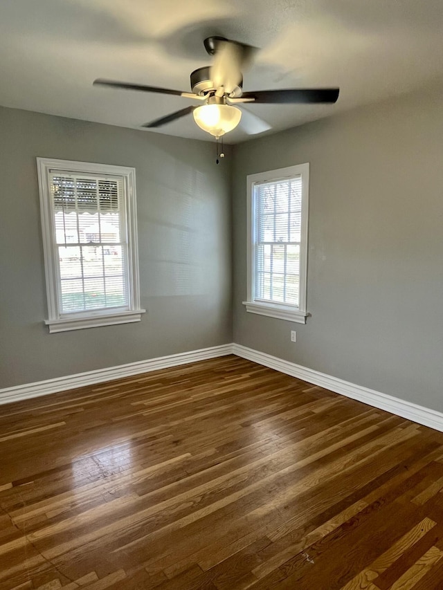 unfurnished room featuring ceiling fan, dark wood-style flooring, and baseboards